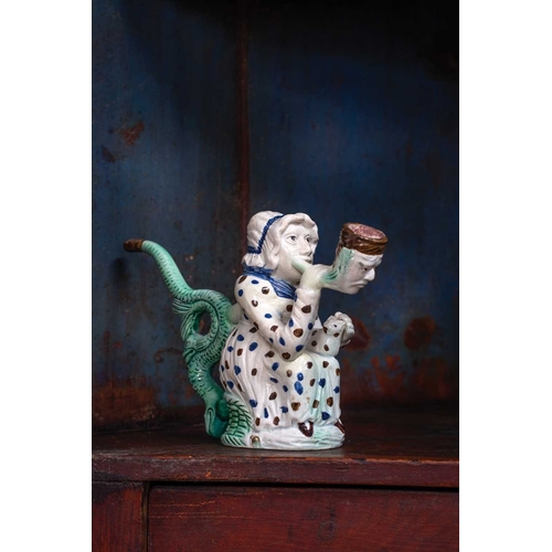 595 - A creamware Martha Gunn pipe. Circa 1790, modelled as the seated woman wearing a blue and brown spot... 