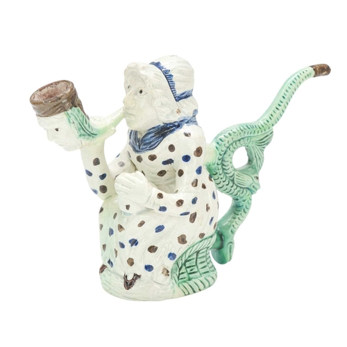 595 - A creamware Martha Gunn pipe. Circa 1790, modelled as the seated woman wearing a blue and brown spot... 