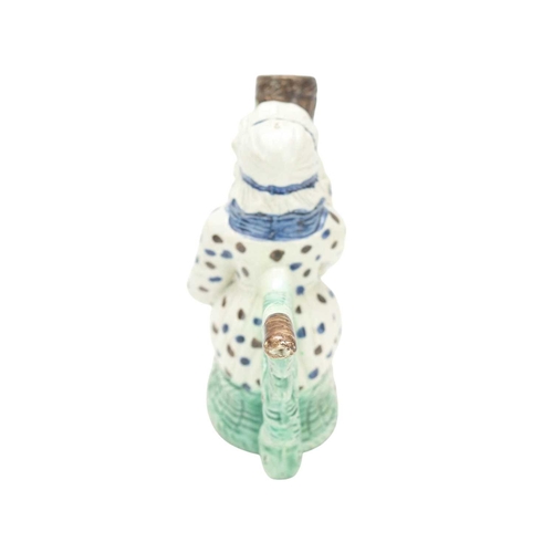 595 - A creamware Martha Gunn pipe. Circa 1790, modelled as the seated woman wearing a blue and brown spot... 