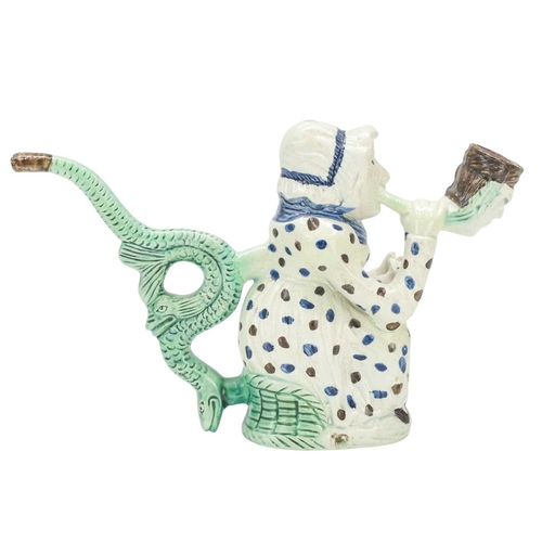 595 - A creamware Martha Gunn pipe. Circa 1790, modelled as the seated woman wearing a blue and brown spot... 
