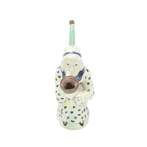 595 - A creamware Martha Gunn pipe. Circa 1790, modelled as the seated woman wearing a blue and brown spot... 