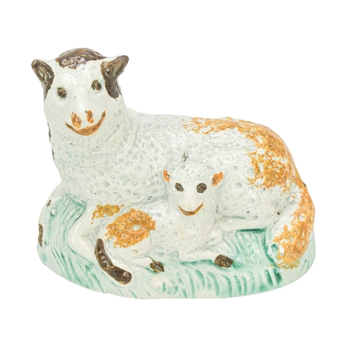611 - A pearlware figure of a recumbent sheep and lamb. Circa 1800, painted in Pratt colours, brown, green... 