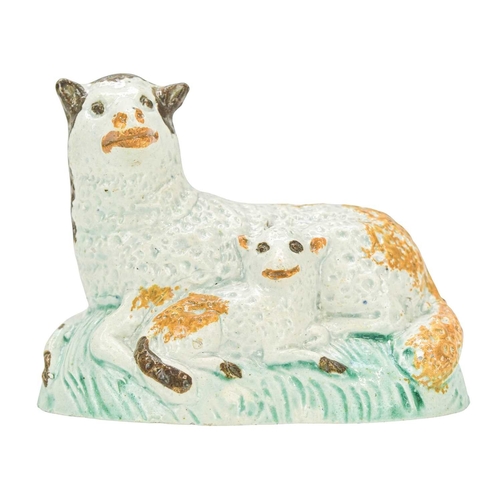 611 - A pearlware figure of a recumbent sheep and lamb. Circa 1800, painted in Pratt colours, brown, green... 