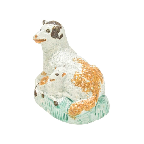 611 - A pearlware figure of a recumbent sheep and lamb. Circa 1800, painted in Pratt colours, brown, green... 