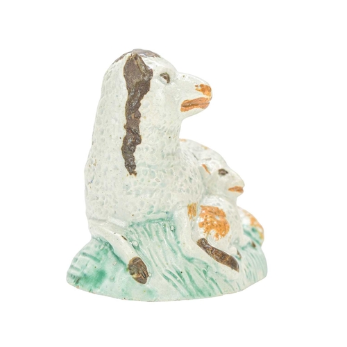 611 - A pearlware figure of a recumbent sheep and lamb. Circa 1800, painted in Pratt colours, brown, green... 