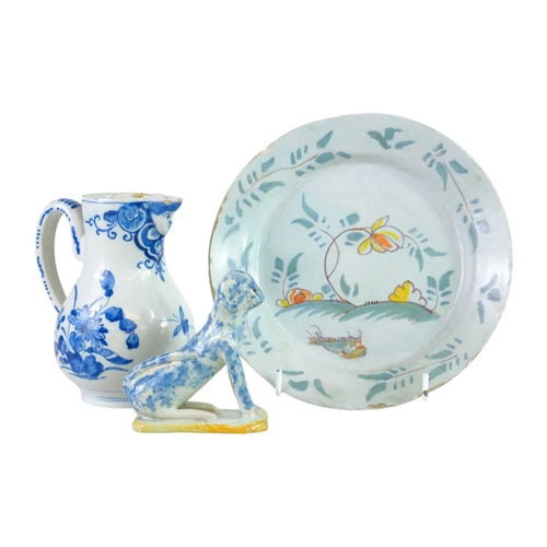 612 - An 18th century Delft jug. Blue painted with floral designs and a moulded face to the spout, height ... 