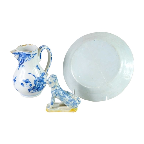 612 - An 18th century Delft jug. Blue painted with floral designs and a moulded face to the spout, height ... 