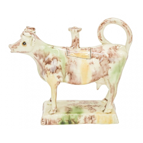 629 - A creamware Whieldon type cow creamer and cover. Circa 1760-1770, with sponged brown, green and ochr... 