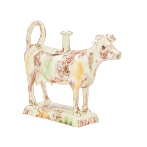 629 - A creamware Whieldon type cow creamer and cover. Circa 1760-1770, with sponged brown, green and ochr... 