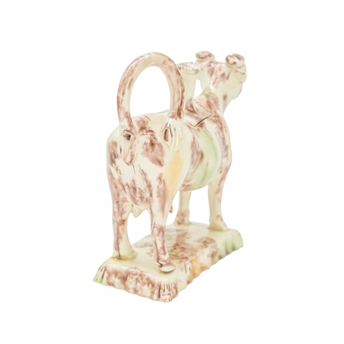 629 - A creamware Whieldon type cow creamer and cover. Circa 1760-1770, with sponged brown, green and ochr... 