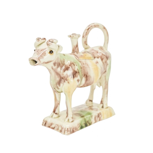 629 - A creamware Whieldon type cow creamer and cover. Circa 1760-1770, with sponged brown, green and ochr... 