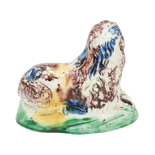 637 - A Whieldon type pottery figure of a lion. Circa 1780, modelled in a recumbent pose and splashed in b... 