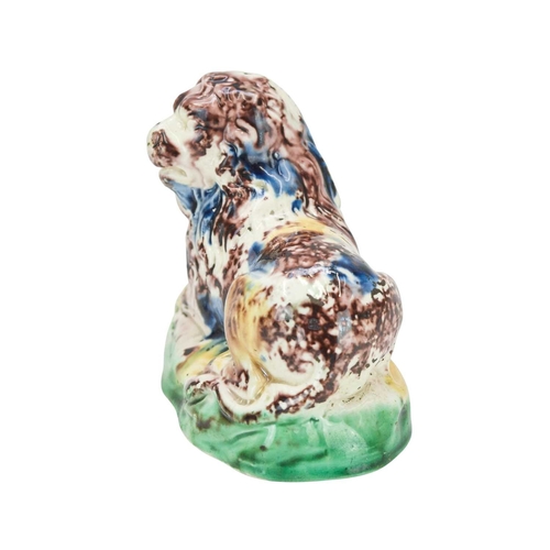 637 - A Whieldon type pottery figure of a lion. Circa 1780, modelled in a recumbent pose and splashed in b... 