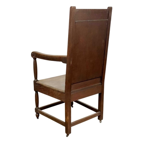 720 - A carved oak wainscot armchair. The panel back dated 1904, and initialled M with a leaf and flowerhe... 