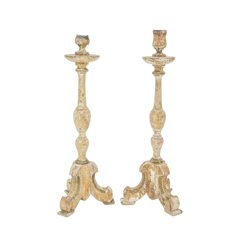 737 - A pair of continental candlesticks Carved pine, gesso and traces of original paint, raised on tripod... 
