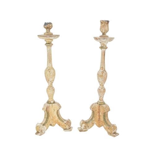 737 - A pair of continental candlesticks Carved pine, gesso and traces of original paint, raised on tripod... 