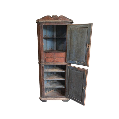 738 - A 19th century painted pine floor standing corner cupboard. With a shaped cornice above an arched pa... 
