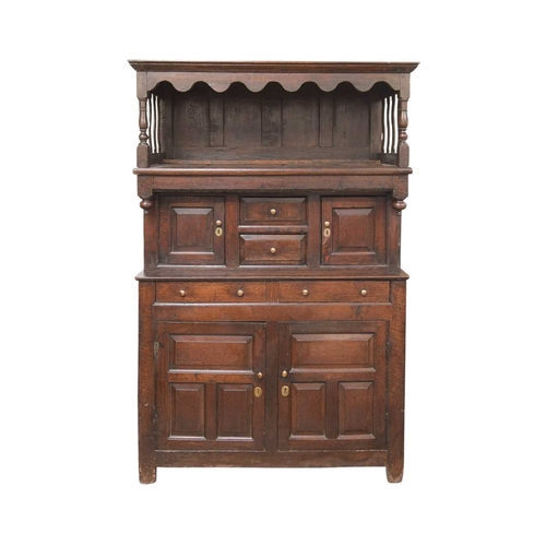 743 - A George III oak tridarn. The raised canopy with turned supports and wavy slatted ends, the centre s... 