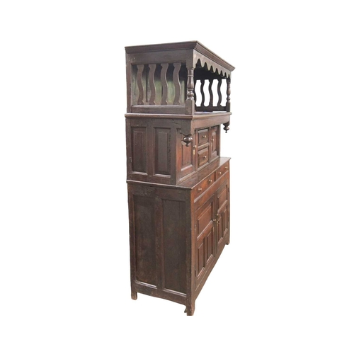 743 - A George III oak tridarn. The raised canopy with turned supports and wavy slatted ends, the centre s... 