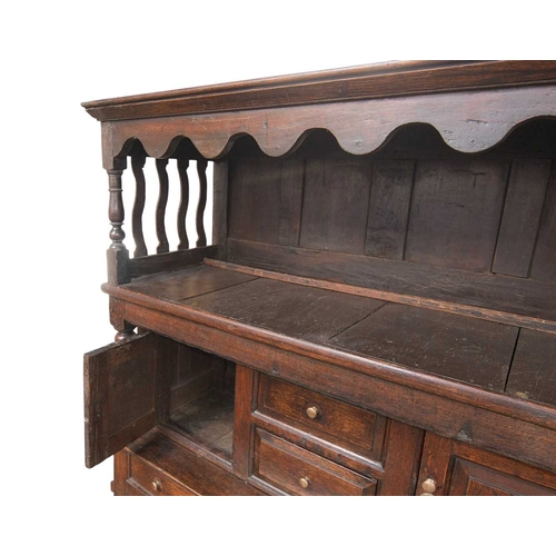 743 - A George III oak tridarn. The raised canopy with turned supports and wavy slatted ends, the centre s... 