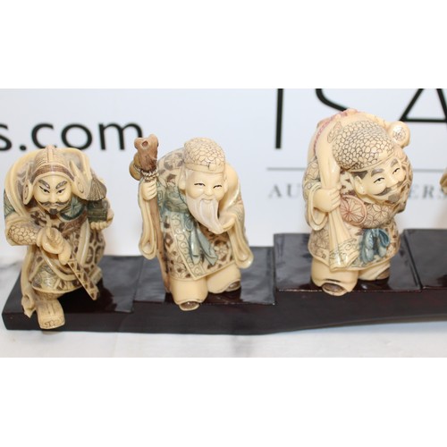 231 - 7 Decorative Japanese Immortals On A Plinth Length-46cm Height Of Figures Tallest 8cm