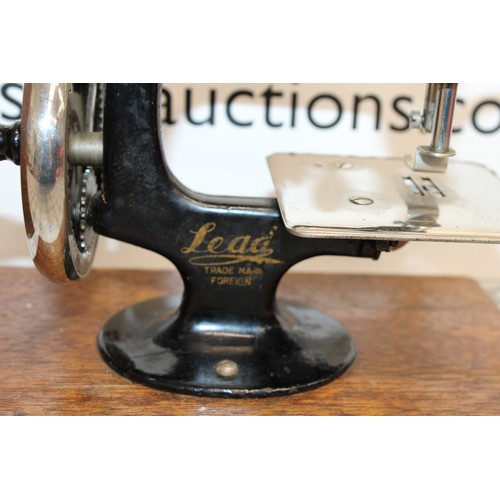 193 - Wooden Cased Lead Miniature Toy Sewing Machine A Japanese 