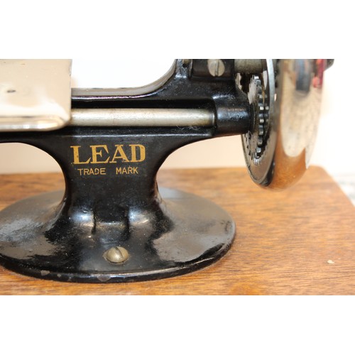 193 - Wooden Cased Lead Miniature Toy Sewing Machine A Japanese 