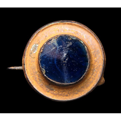 16 - Roman glass centre boss brooch, 3rd - 4th century AD. A bronze disc brooch at the centre of which is... 