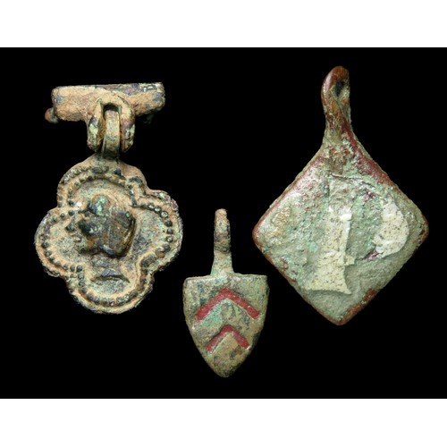 78 - Medieval heraldic pendant group. Circa 13th-14th century AD. Copper-alloy, largest 38mm x 21mm. Thre... 