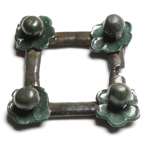 118 - Medieval brooch. A  medieval open-framed brooch of square form with a stylised repousse flower attac... 