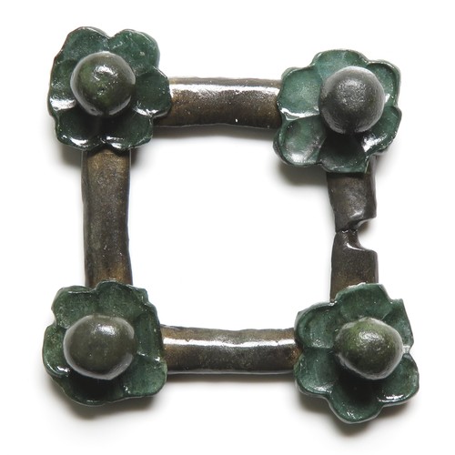 118 - Medieval brooch. A  medieval open-framed brooch of square form with a stylised repousse flower attac... 