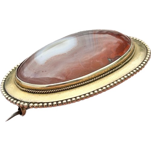 132 - Victorian Gold Brooch, Circa 19th century. 15.38g. 44 x 32 mm. A large Scottish agate stone framed w... 