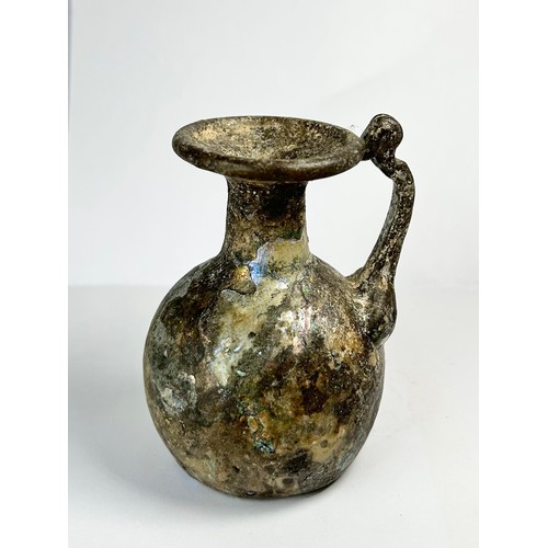 68 - Roman Glass Juglet. Circa 3rdcentury CE. 77mm x 54mm. A beautifully well preserved glass vessel form... 