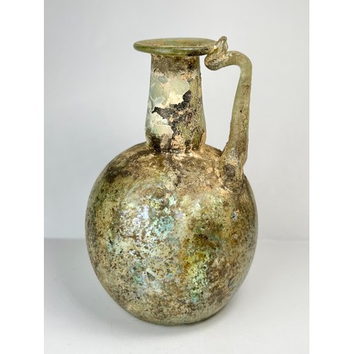 70 - Roman Glass Single Handled Flask. Circa 4th century CE. 110mm x 72mm. A beautifully well preserved g... 