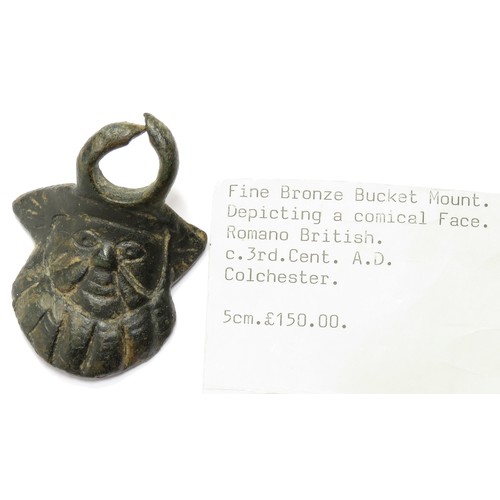 95 - Roman Anthropomorphic Mount. Circa 3rd century CE. A vessel mount with a large suspension loop, cast... 