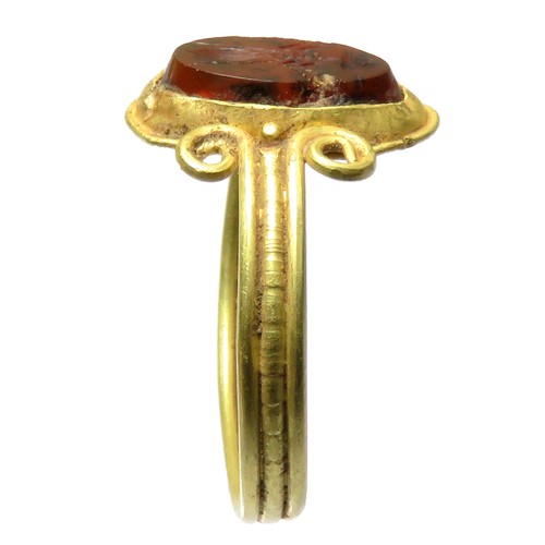 59 - Greek Intaglio Gold Ring. Circa 5th-4th century BCE. A polished garnet intaglio depicting a stylised... 