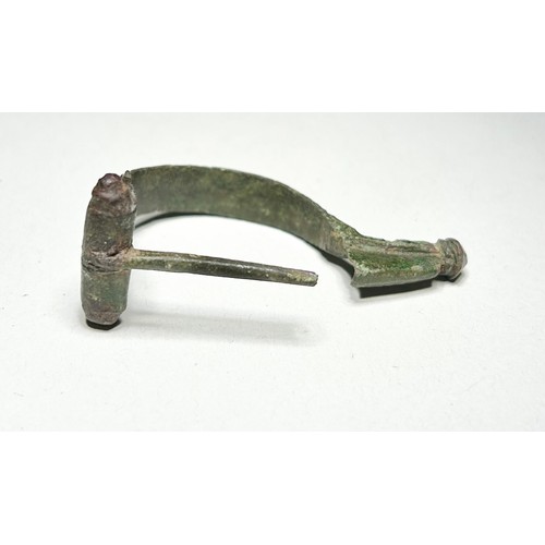 21 - Roman inscribed Aucissa bow brooch. Circa 43-70 CE. 51 mm. 9.12g. Formed of an arched bow that is de... 