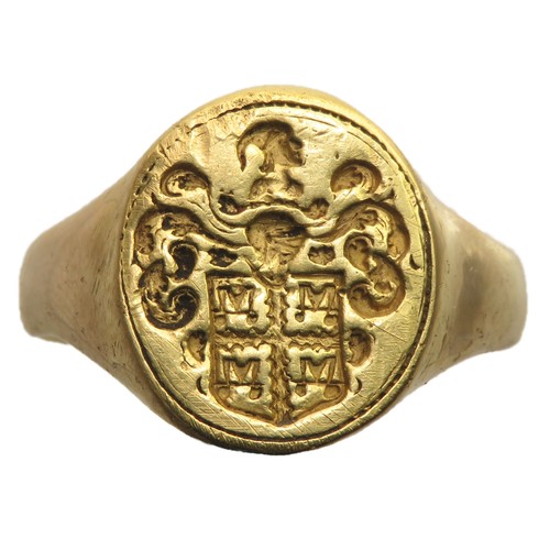 17th Century Bourchier Family Armorial Signet Ring. Gold, 7.85g. 21mm, 17mm internal. Ring size UK N + 1/2, US 7. Formed of a plain band with wide shoulders that support an oval bezel. The face of the bezel is engraved with an armorial seal displaying the arms of Bourchier. Argent, a cross engrailed gules between four water bougets sable. 