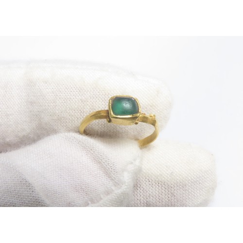 44 - Roman gold ring with green glass cabochon. Circa 3rd-4th century CE. A fine D-sectioned band with a ... 