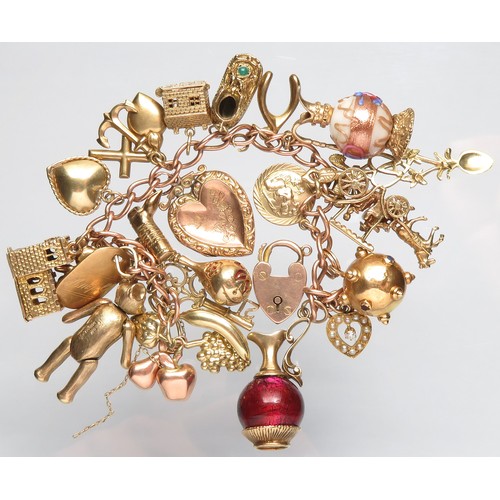 76 - Gold charm bracelet 89.5g total 9ct with 21 charms including a gem-set heart, heart locket, 2 jugs w... 