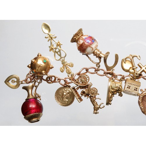 76 - Gold charm bracelet 89.5g total 9ct with 21 charms including a gem-set heart, heart locket, 2 jugs w... 