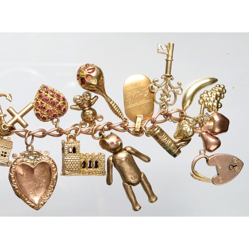 76 - Gold charm bracelet 89.5g total 9ct with 21 charms including a gem-set heart, heart locket, 2 jugs w... 