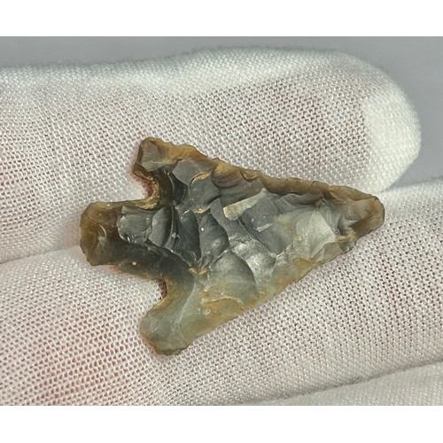 101 - A complete Early Bronze Age barbed and tanged flint arrowhead. Circa 2500-1500 BCE. Knapped from a m... 