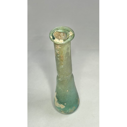 118 - Roman Glass Unguentarium. Circa 1st-2nd century CE. 126mm. A blue/green glass bottle with an elongat... 