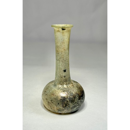 119 - Roman Glass Unguentarium. Circa 1st-2nd century CE. 84mm. A clear / iridescence glass bottle with an... 