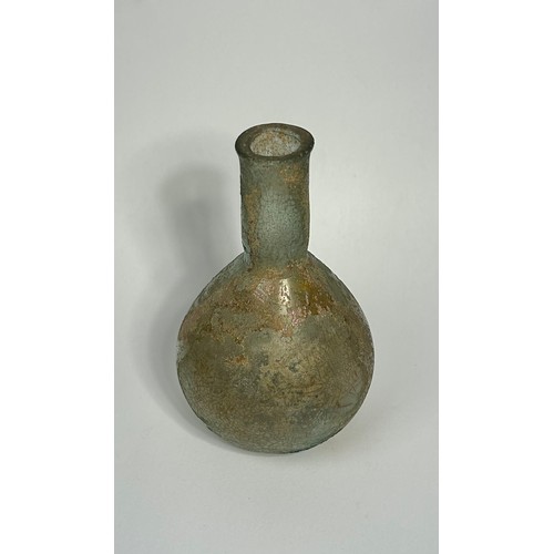 39 - Roman glass bottle. Circa 2nd century CE. 85mm x 35mm. A bulbous body with a straight sided narrow n... 