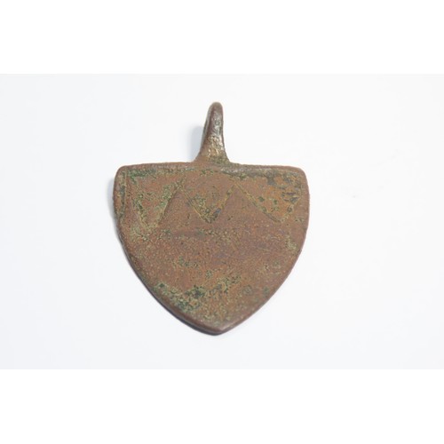 100 - Medieval heraldic harness pendant. Circa 13th century CE. Copper-alloy, 16.55g. 51mm. A shield-shape... 