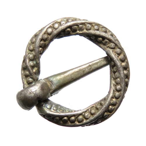 107 - A small silver Medieval annular brooch, circa 1200-1400 CE. Formed of a twisted square sectioned fra... 