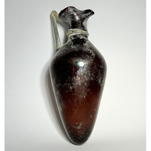 37 - Roman blown glass amphora type jug. Circa 1st-2nd century CE. 18 cm. A Translucent purple vessel wit... 