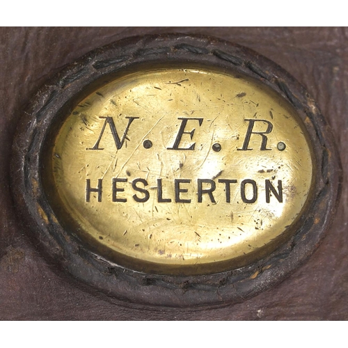 438 - A North Eastern Railway cash bag with a brass plate, N.E.R. HESLERTON. The station was between Malto... 